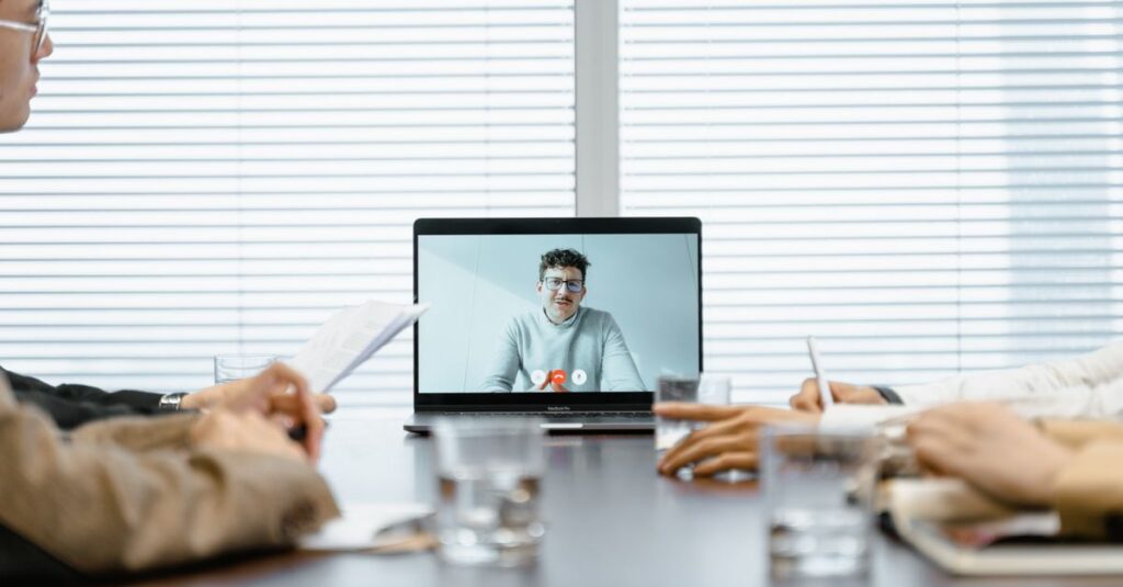 A diverse group participates in a virtual meeting using modern technology.